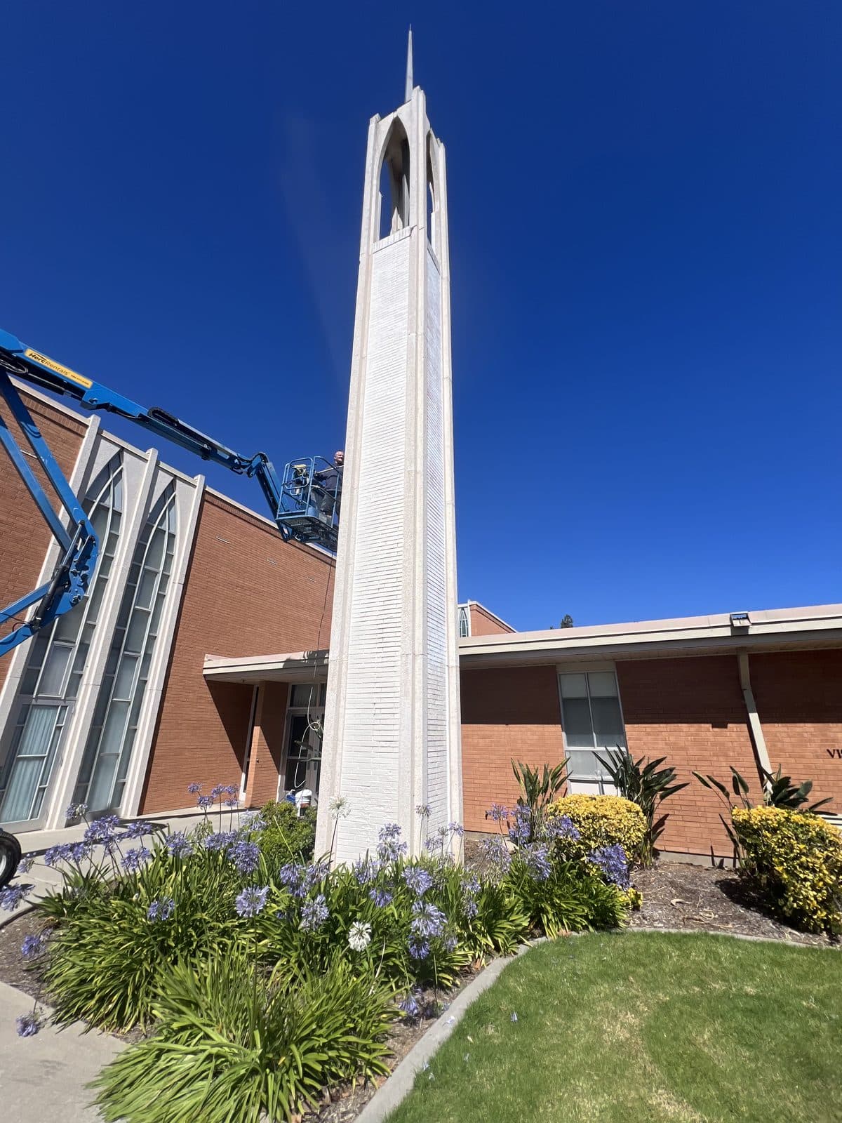 Freshly repainted white church steeple against a blue sky